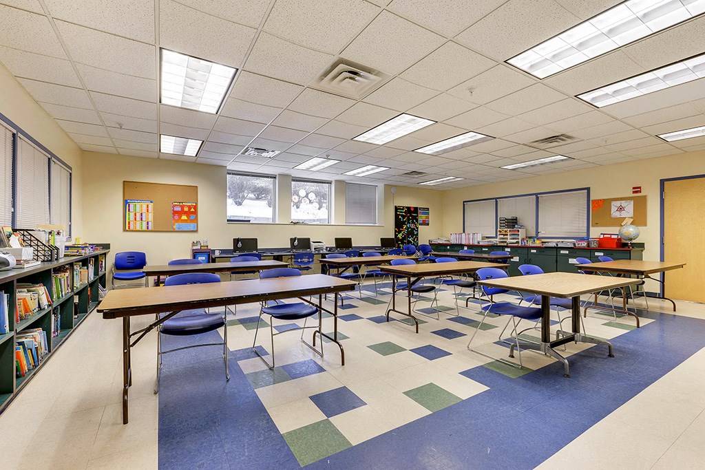 a classroom with tables and chairs in a library