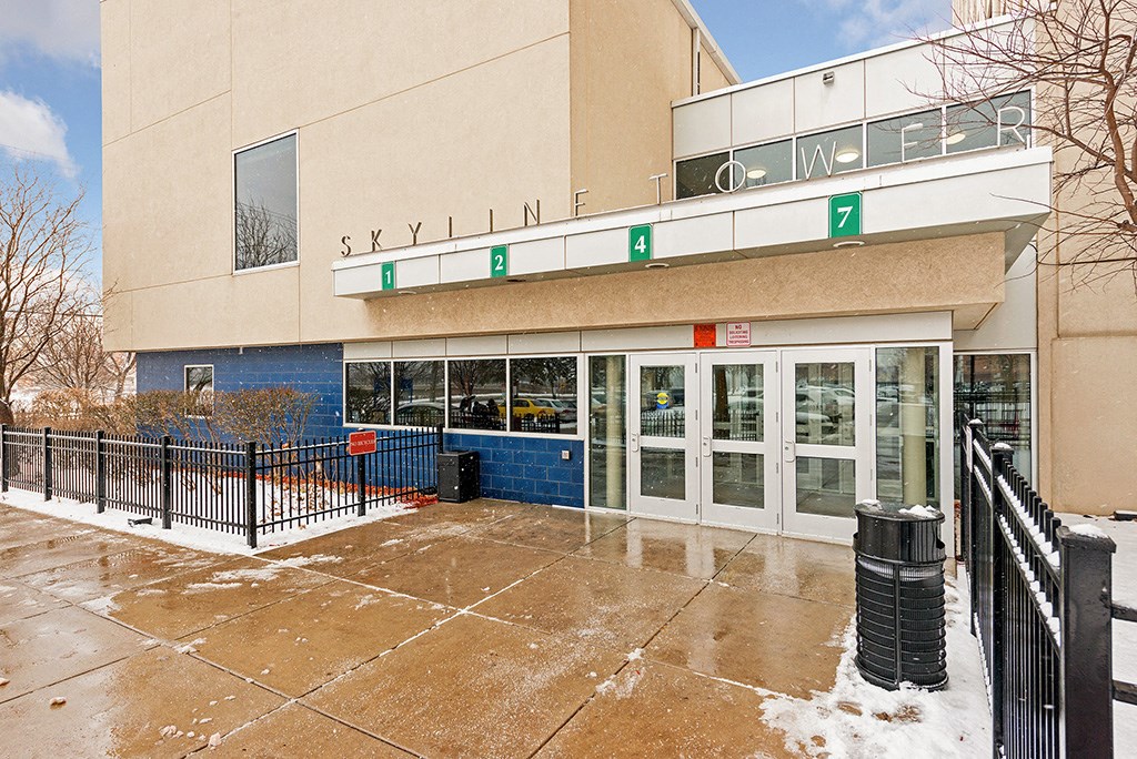 a city building with doors and a sidewalk in the snow
