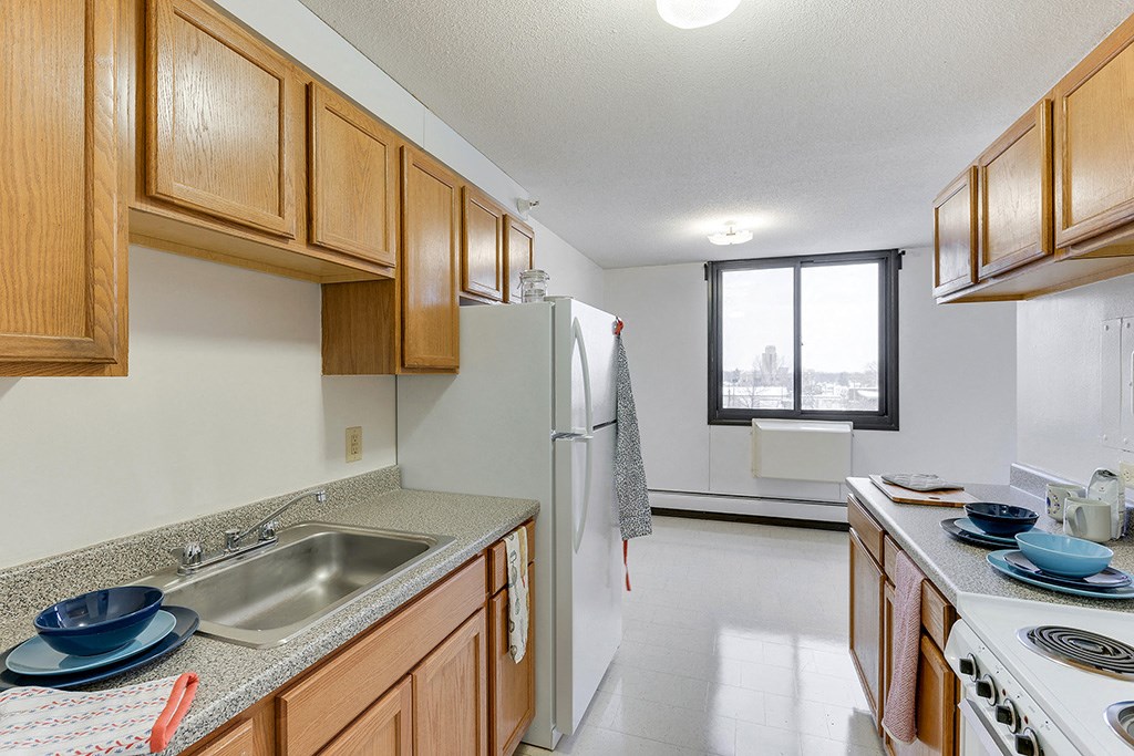 a kitchen with wooden cabinets and a sink and a refrigerator