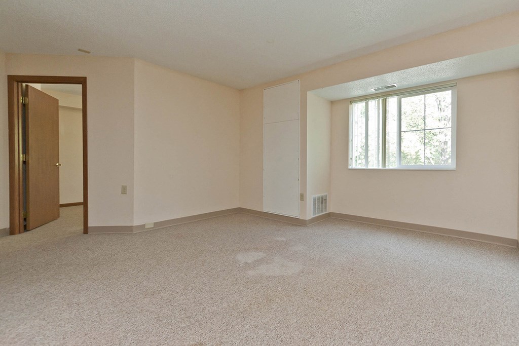 an empty living room with a window and a door
