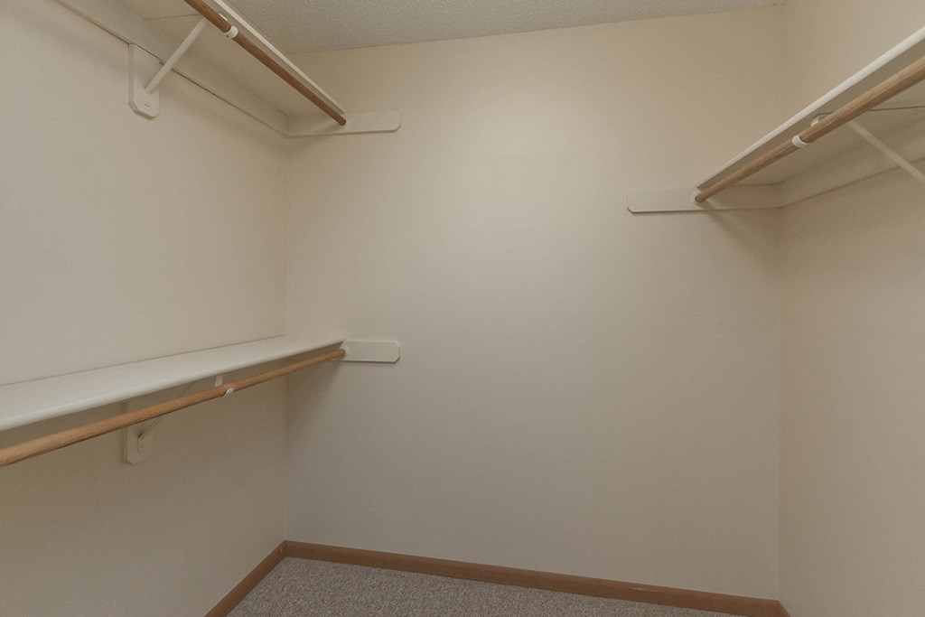 a empty room with a white wall and a hanging rack