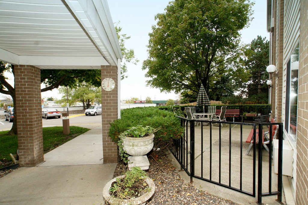 a porch outside of a building with a black iron fence