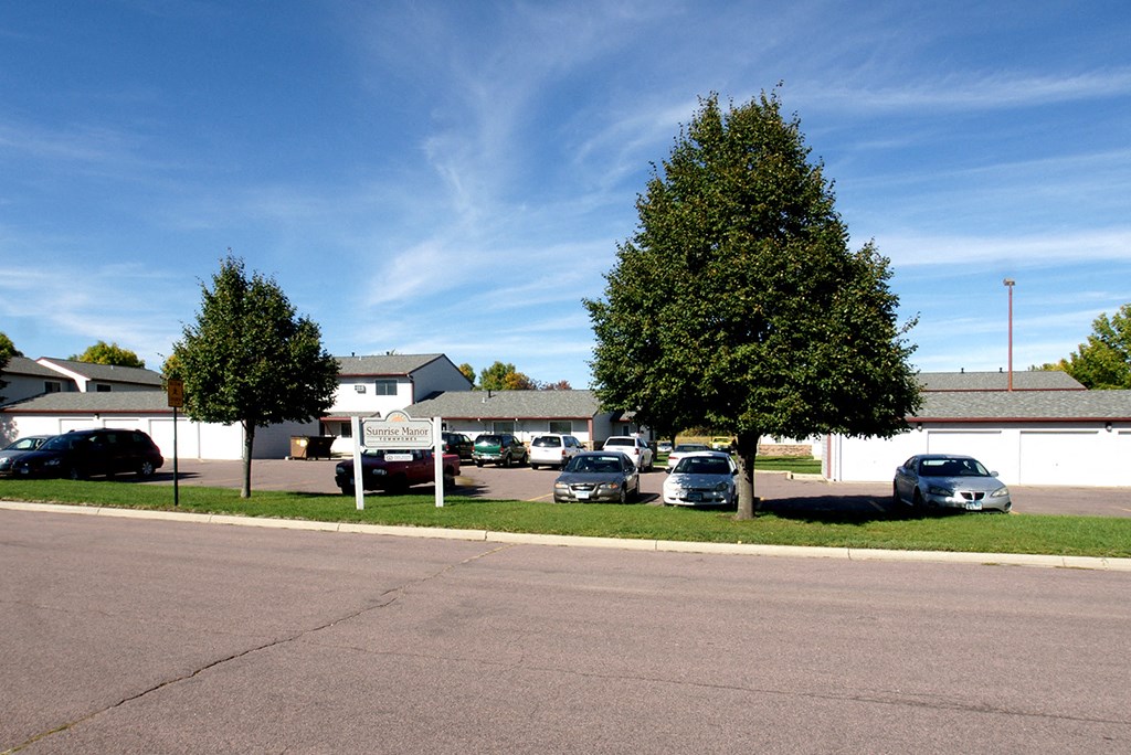 a parking lot with cars parked in front of a house