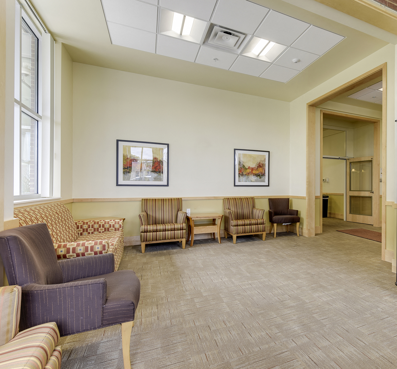 a living room with couches and chairs and a doorway
