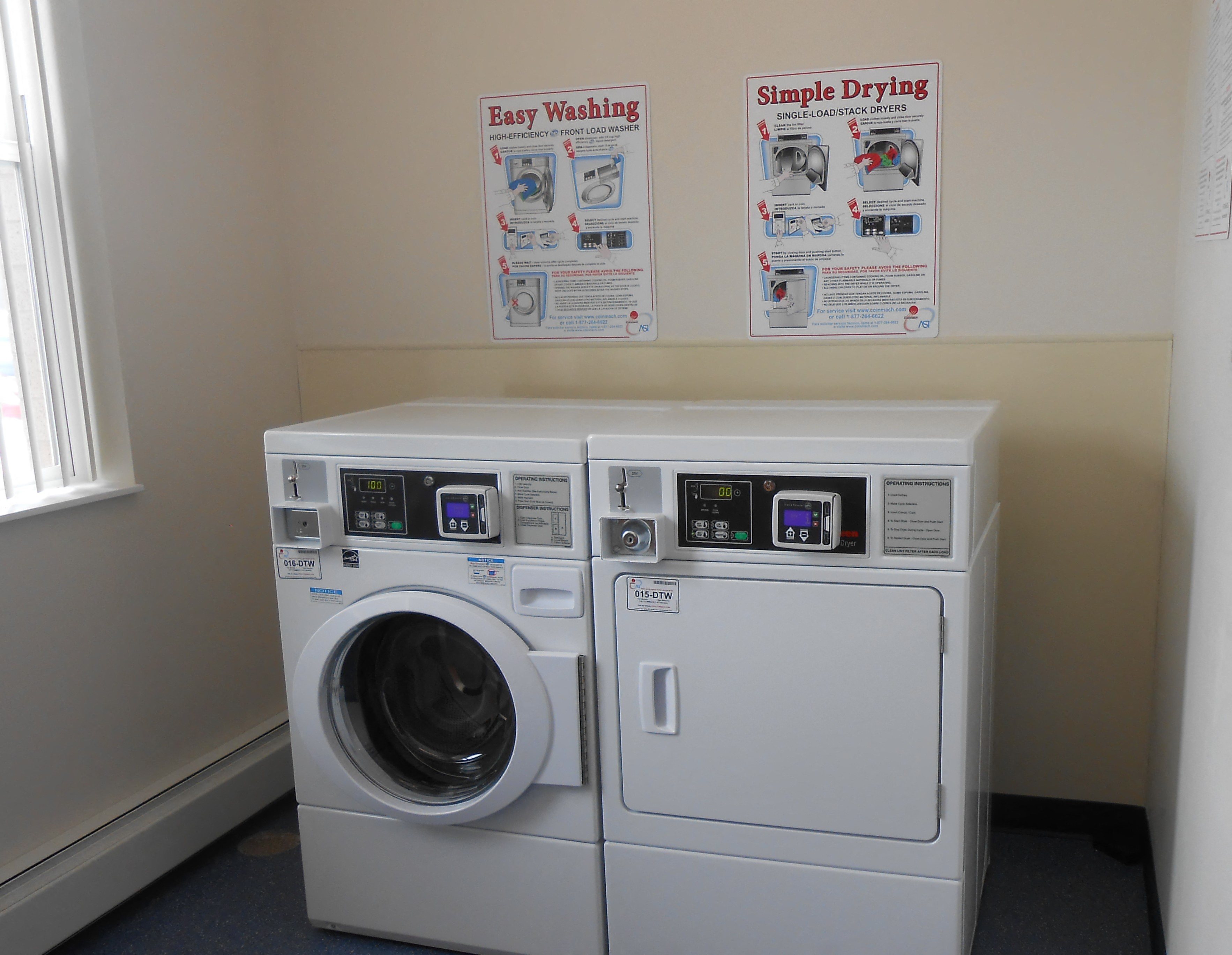 a washer and dryer in a laundry room with signs on the wall