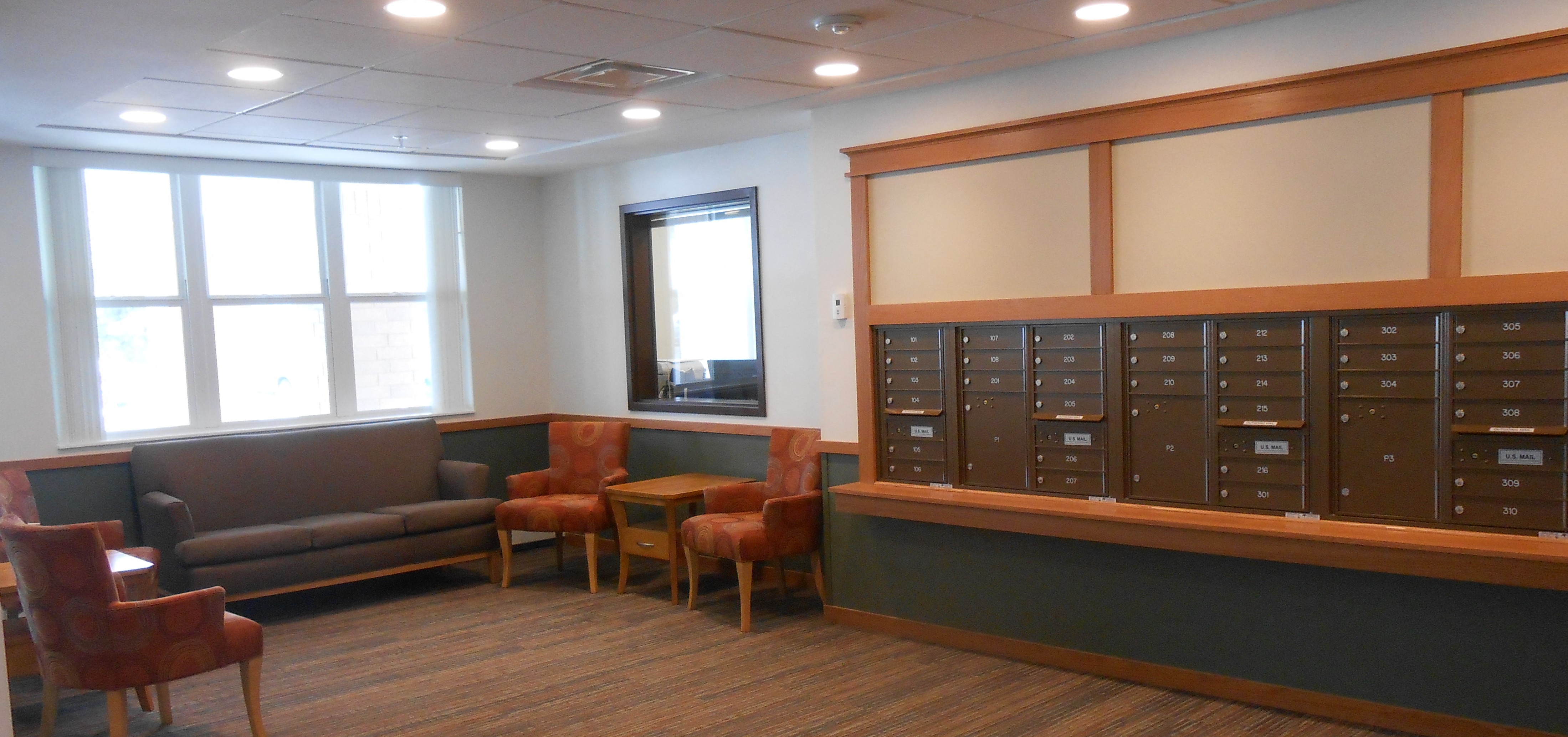 a room with couches and chairs and a filing cabinet