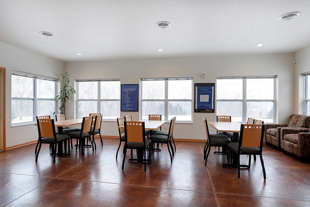 a dining room with a table and chairs in a room with windows