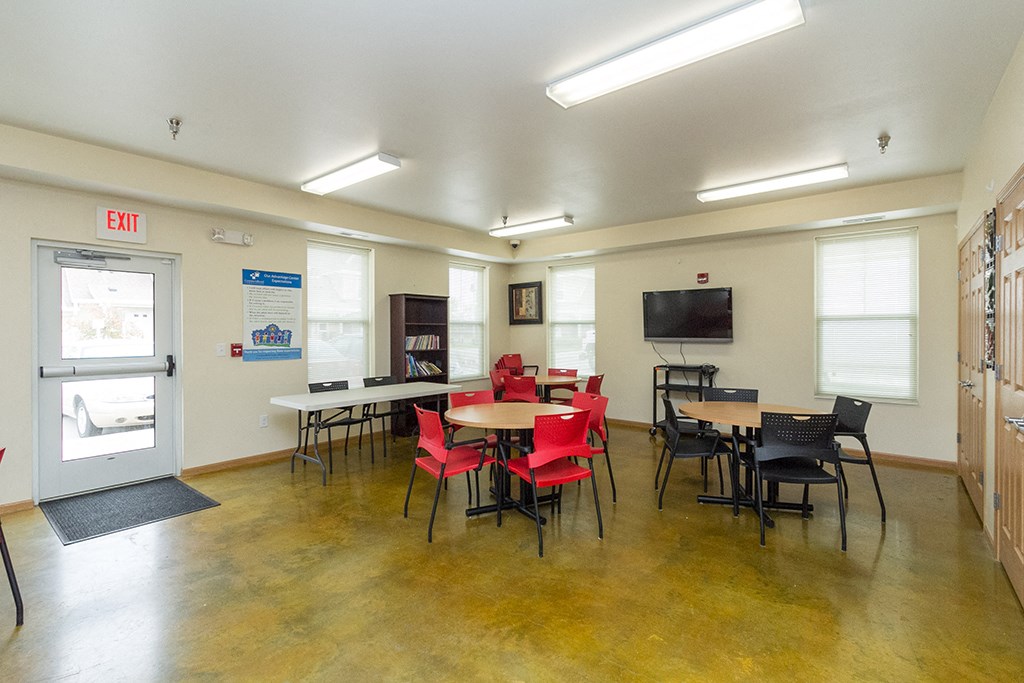 a dining room with tables and chairs and a tv
