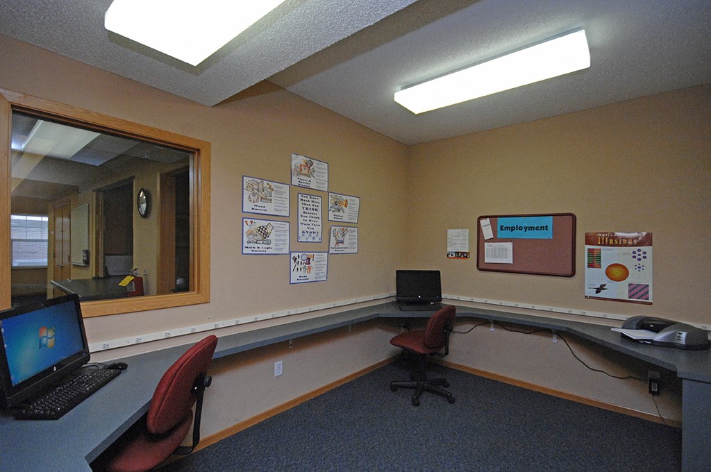 an office with two chairs and a desk with a laptop