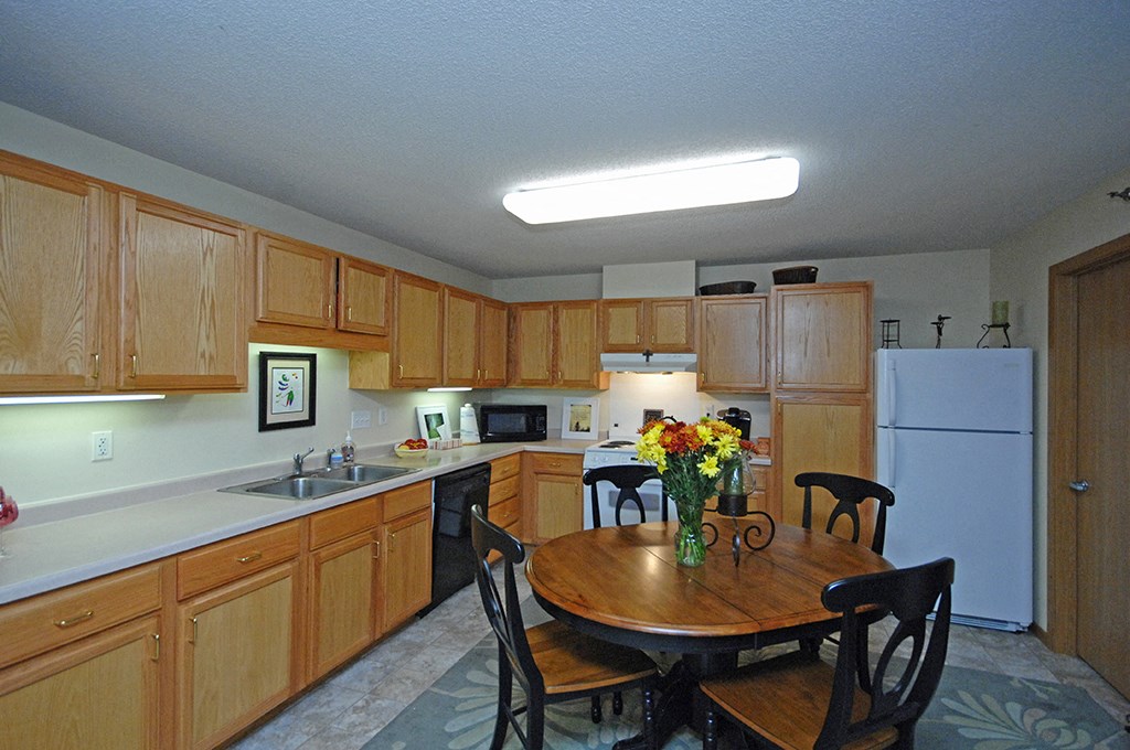 a kitchen with wooden cabinets and a table with flowers