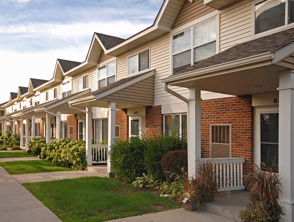 a row of houses with a sidewalk in front of them
