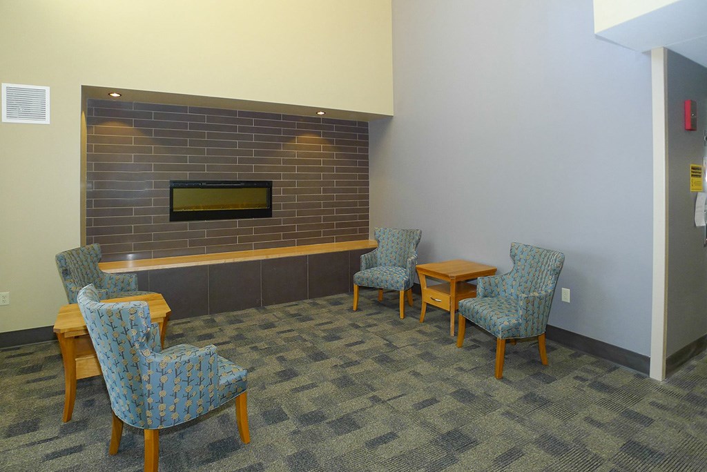 a lounge area with chairs and a fireplace
