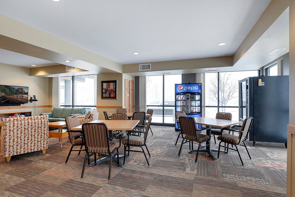 a dining room with tables and chairs and a vending machine