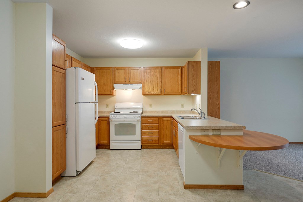 a kitchen with white appliances and wooden cabinets