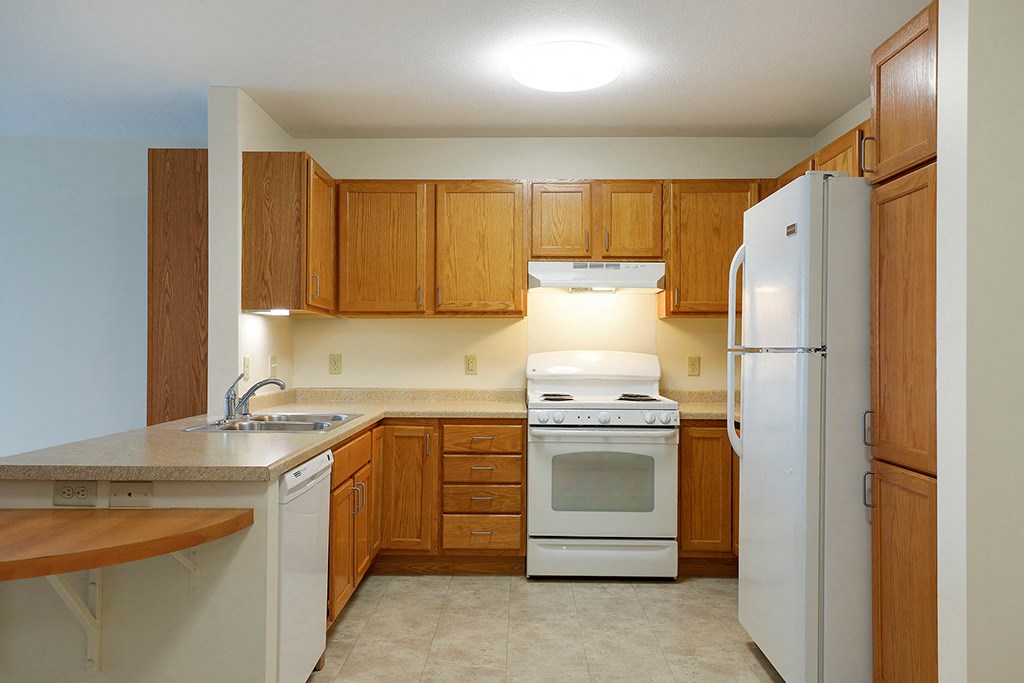 a kitchen with white appliances and wooden cabinets