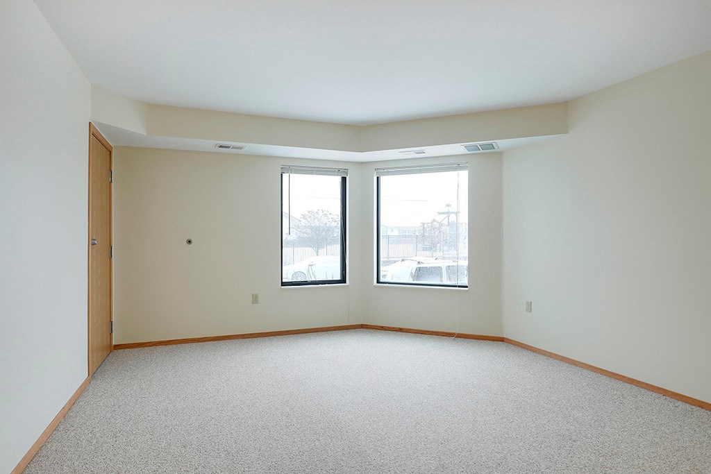 the living room of an empty house with two windows