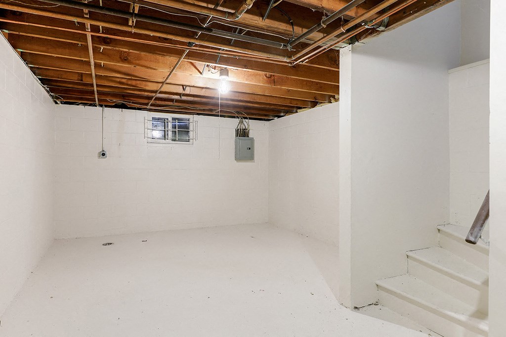 a room with white walls and a white staircase