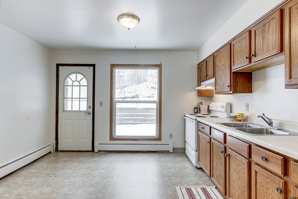 an empty kitchen with wooden cabinets and a sink