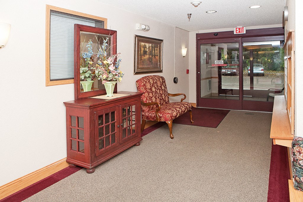 a room with a chair and a dresser and a door