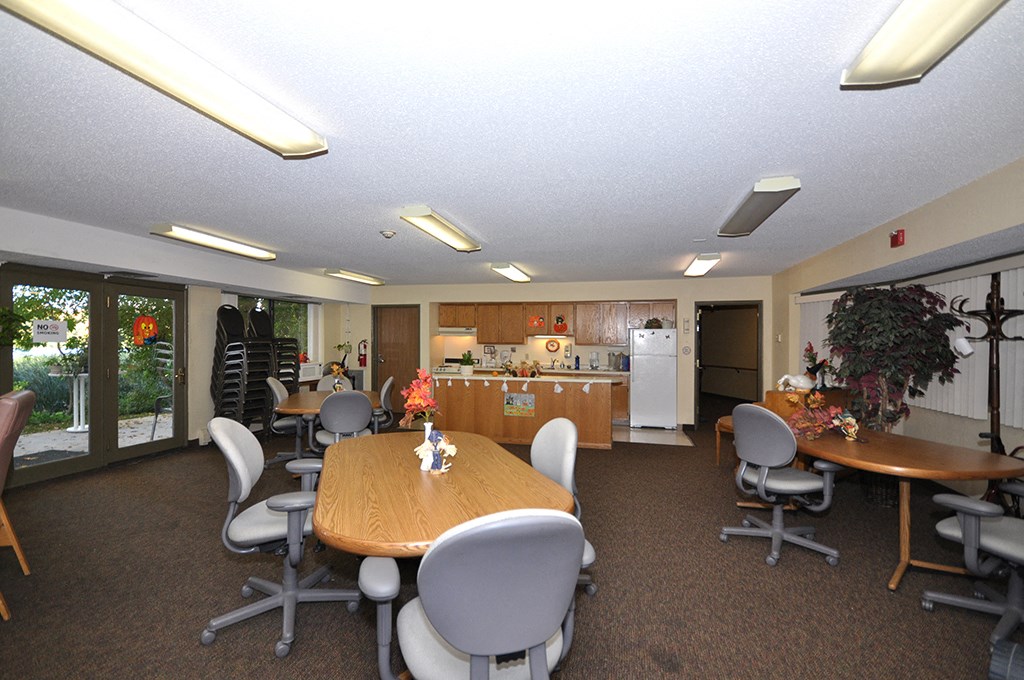 a conference room with a table and chairs and a kitchen