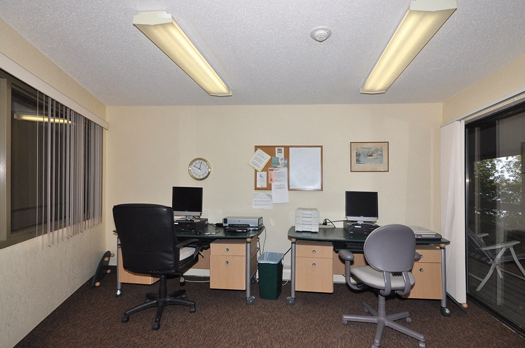 an office with two desks and two computer monitors