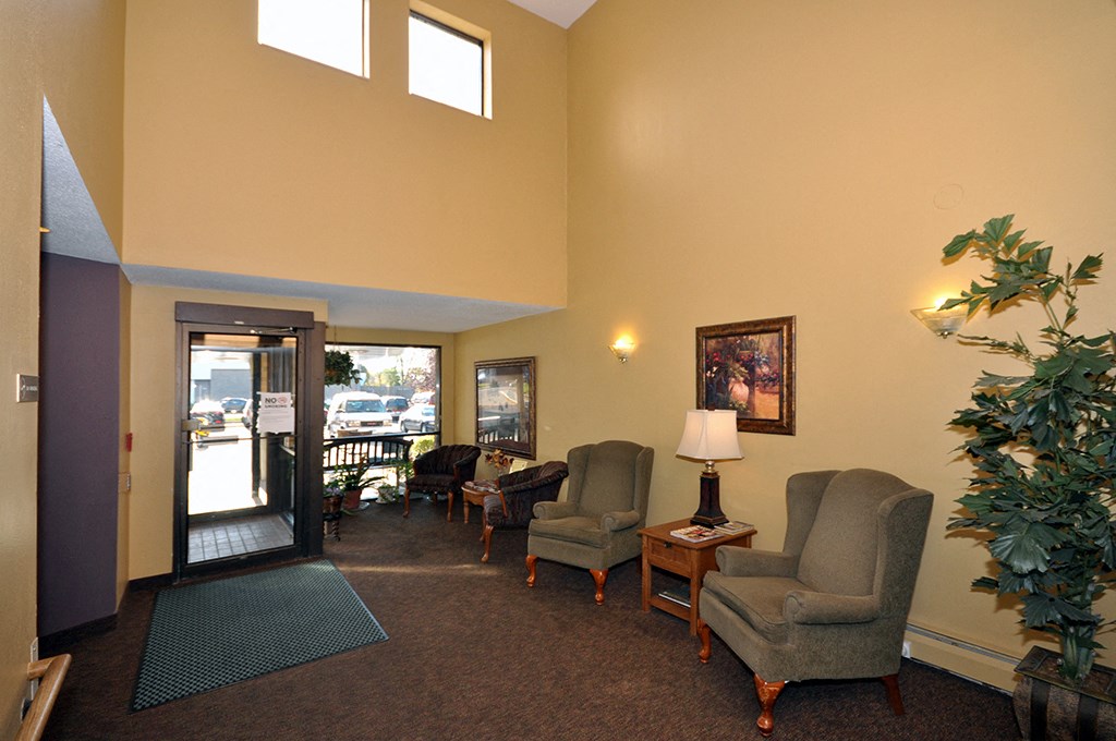 a living room with chairs and a door to a balcony