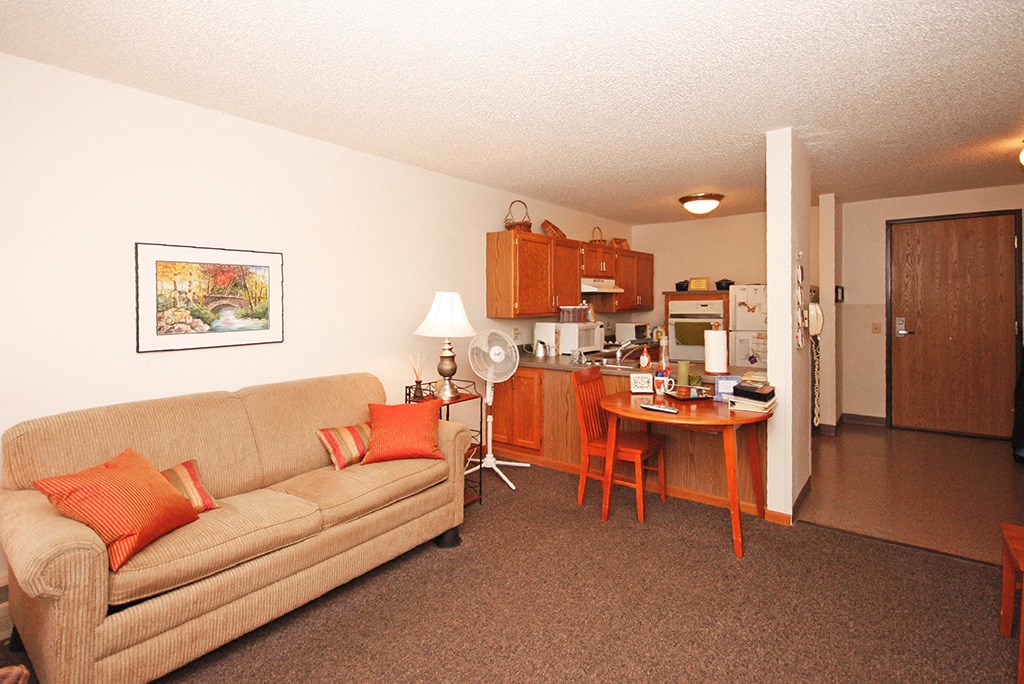 a living room and kitchen with a couch and a table