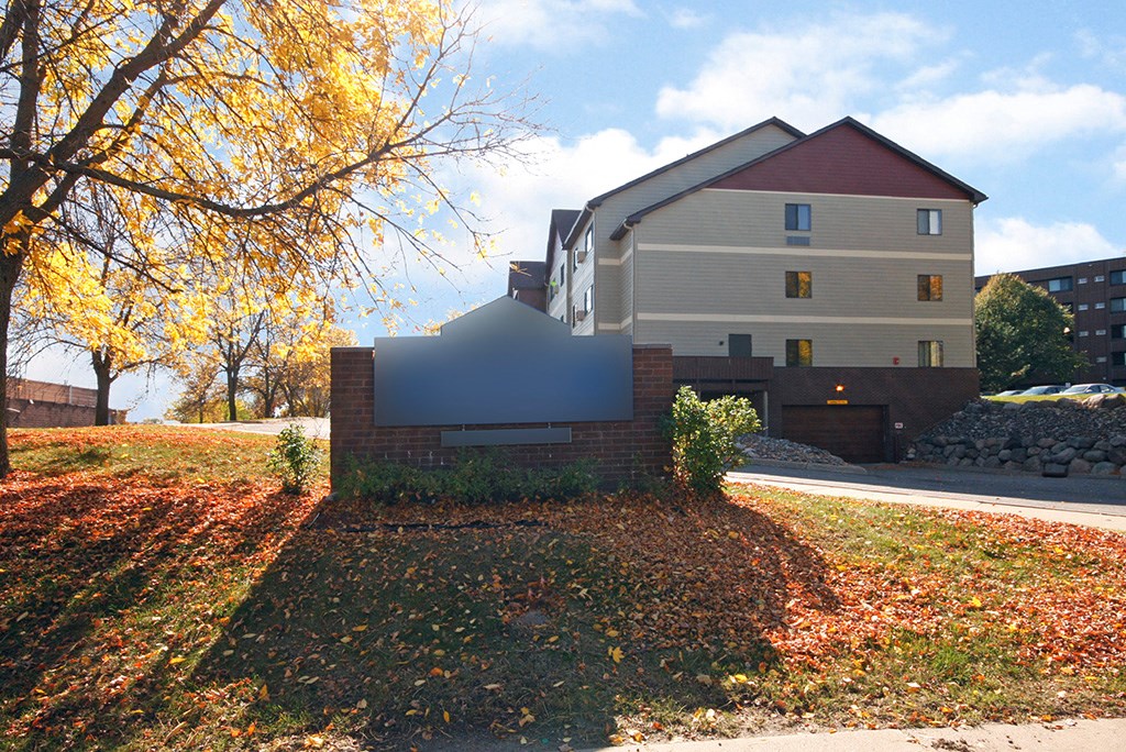 a house on the side of a street with a tree in front of it