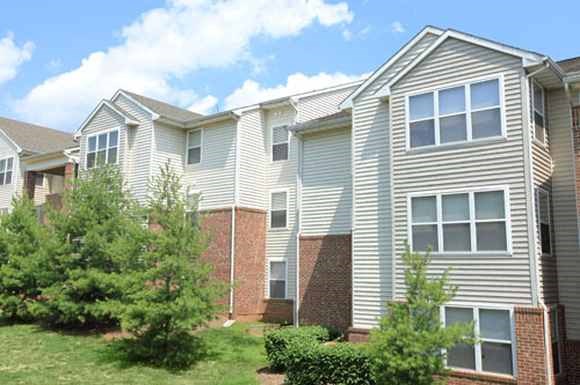 an apartment building with trees in front of it