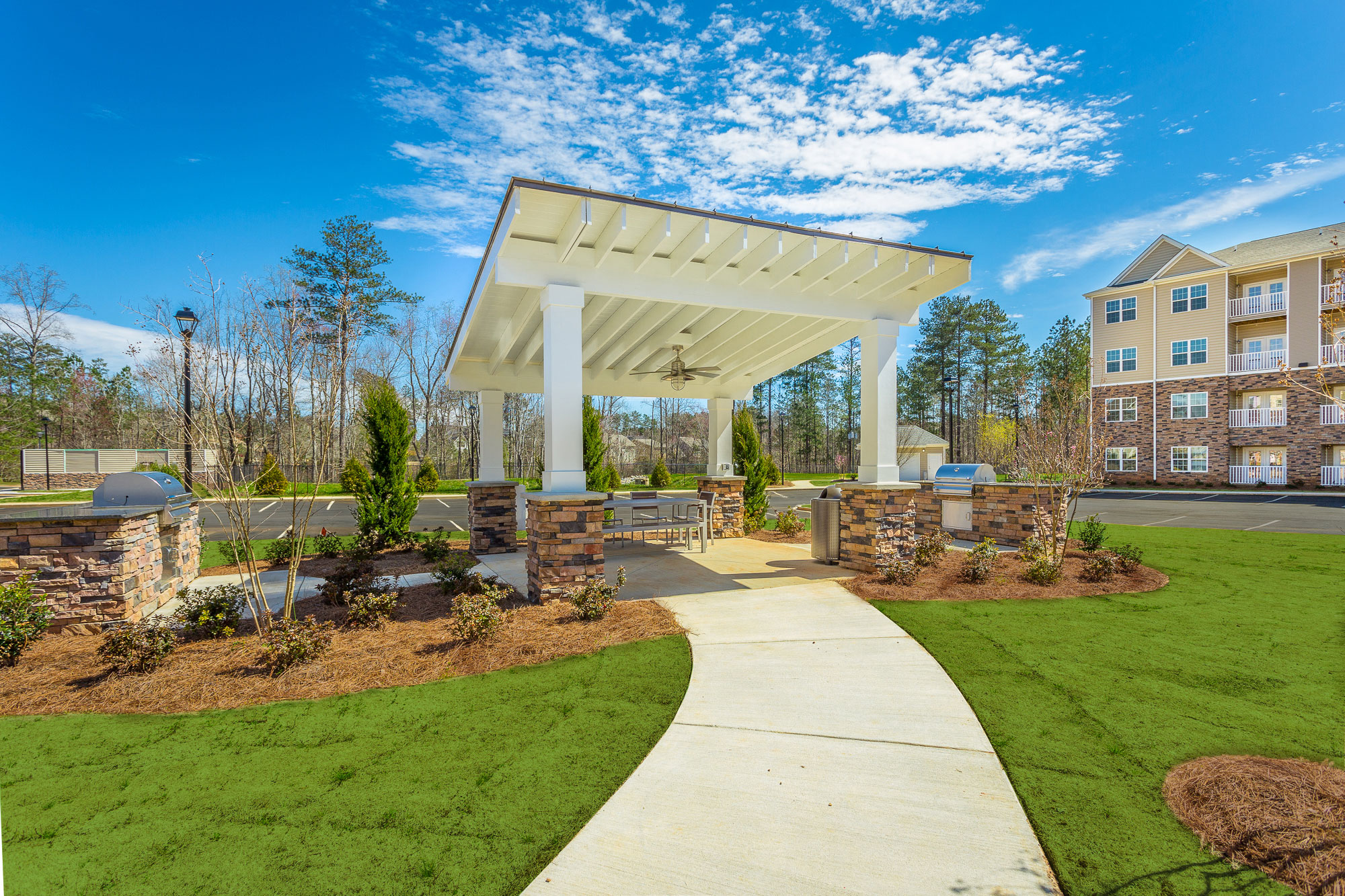 a white gazebo at the end of a sidewalk