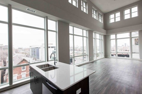 A kitchen with a large island and a view of the city.
