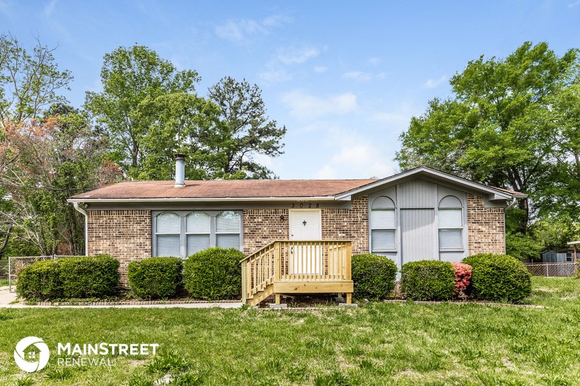 a small brick house with a wooden deck in front of it