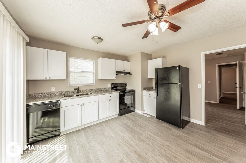 a kitchen with stainless steel appliances and a ceiling fan