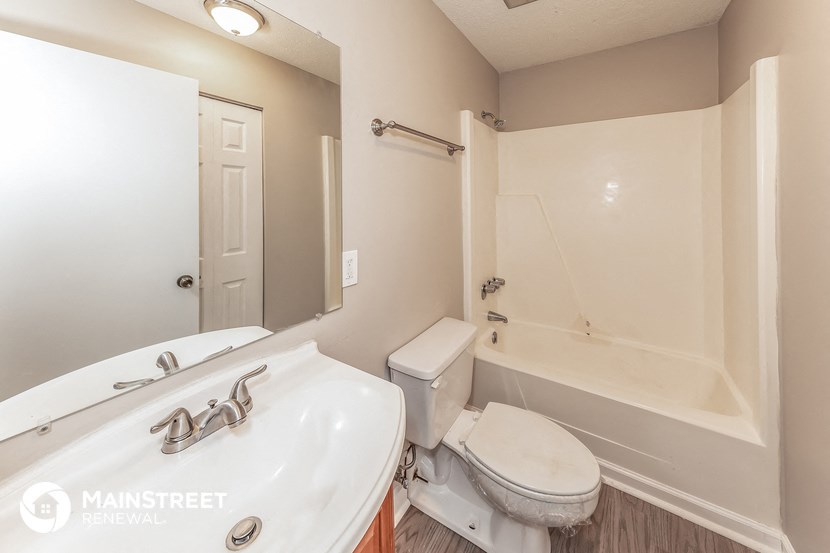 a bathroom with a toilet and a sink and a tub
