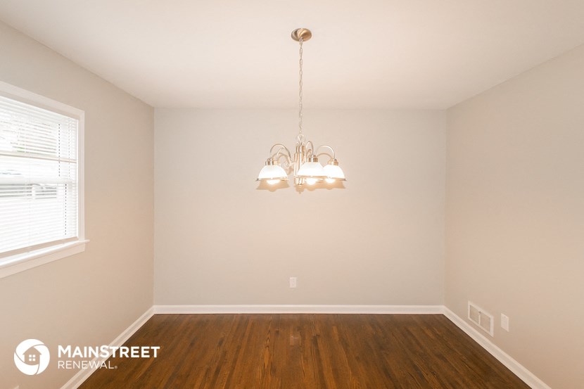 a living room with wood floors and a chandelier