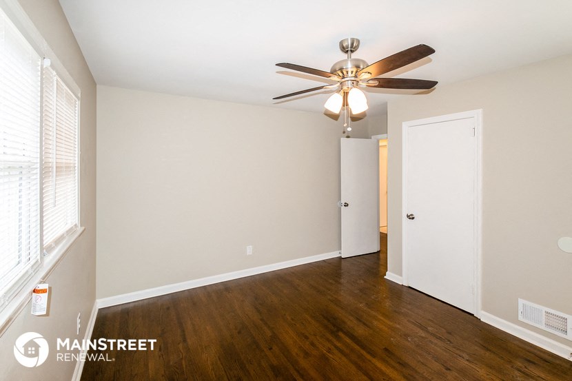 a living room with wood flooring and a ceiling fan