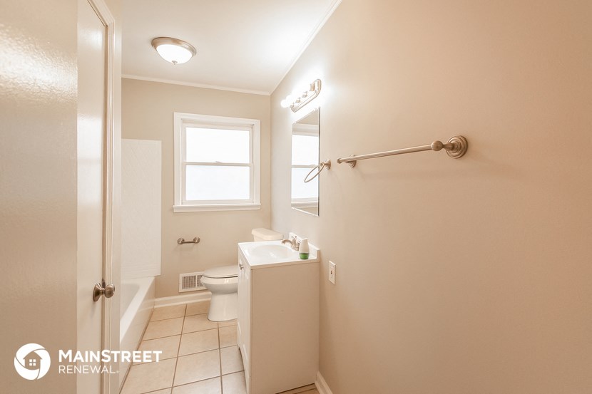 a bathroom with a toilet and a sink and a window
