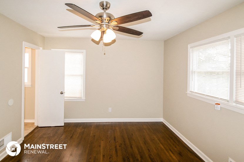 the master bedroom has a ceiling fan and hardwood floors