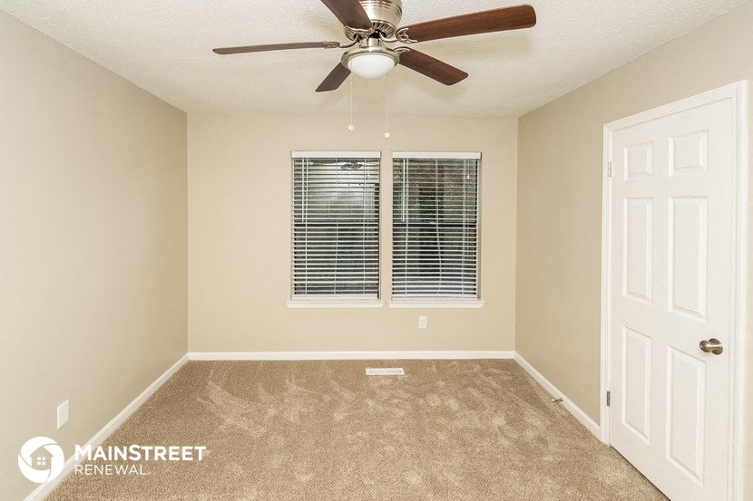 the master bedroom has a ceiling fan and a window