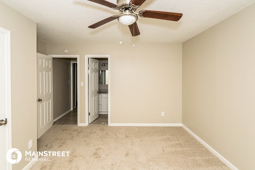 the master bedroom is spacious and has a ceiling fan