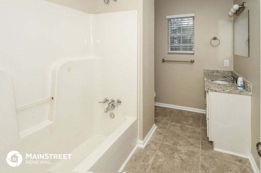 a bathroom with a tub and a sink and a mirror