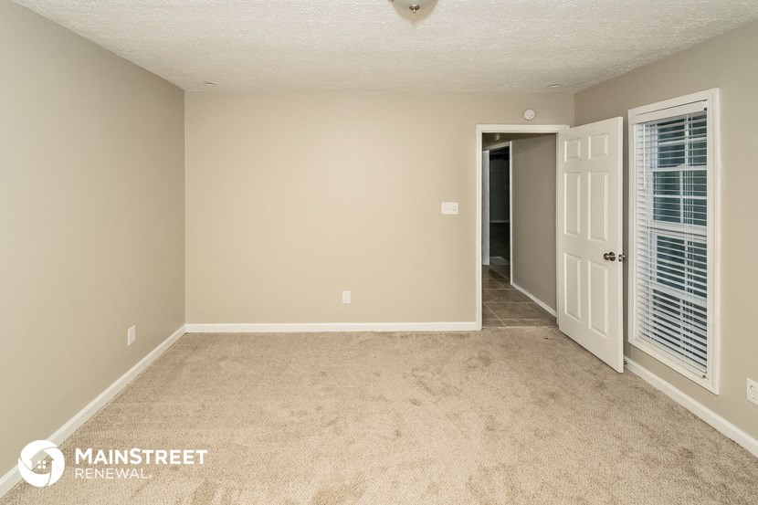 an empty living room with a door to a hallway