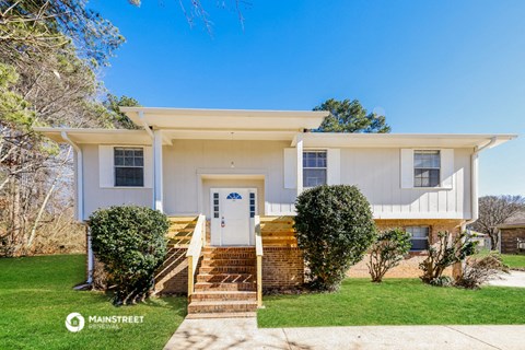 a white house with a blue door and a lawn