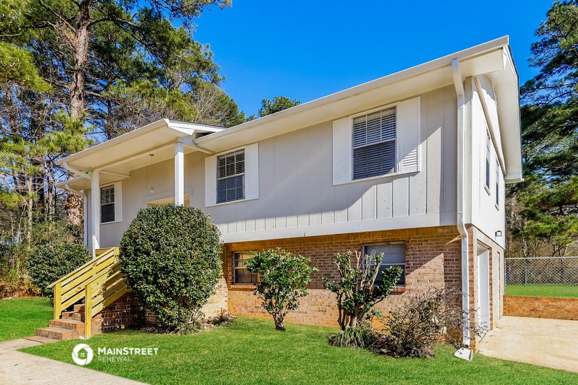 a white and brick house with a porch and a lawn