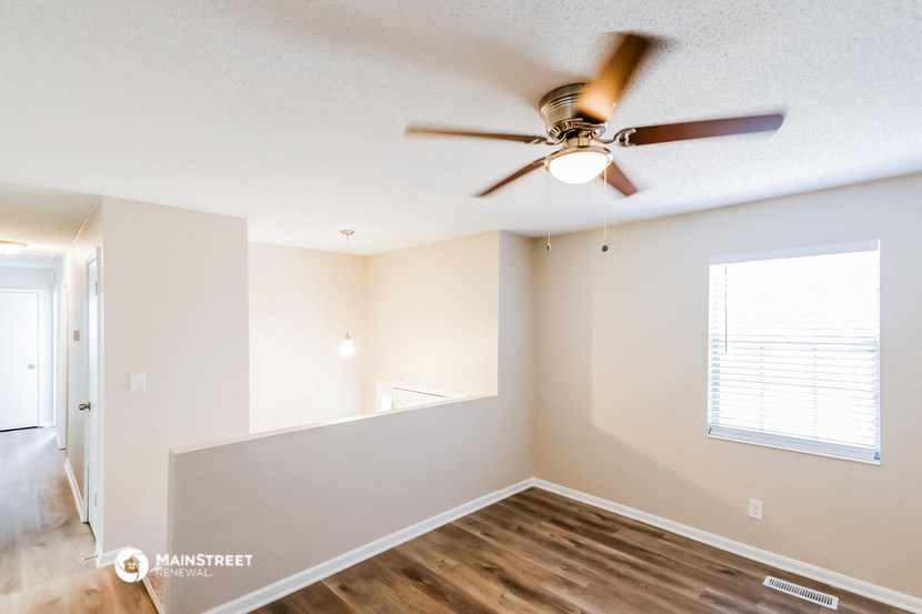 a living room with a ceiling fan and a window
