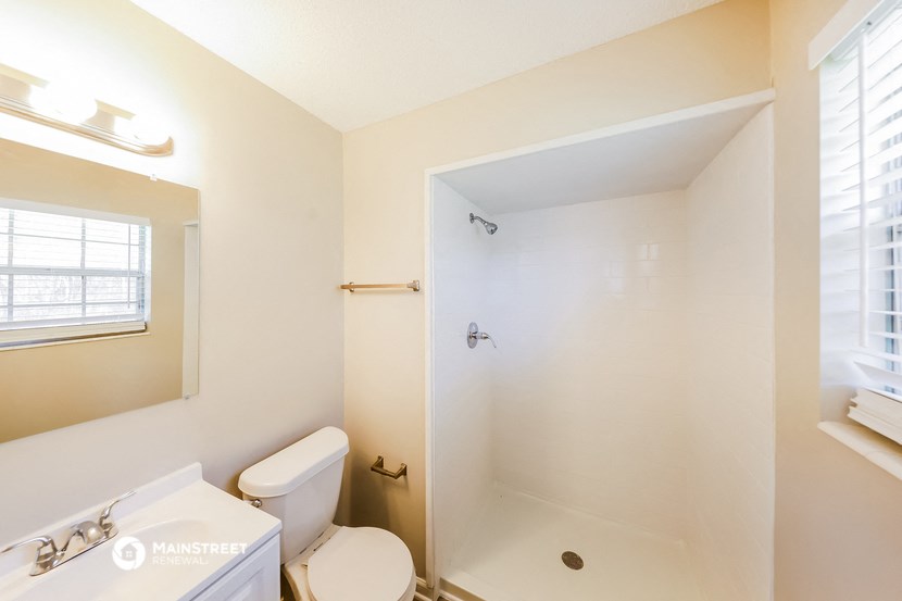 a bathroom with a shower and a toilet and a sink