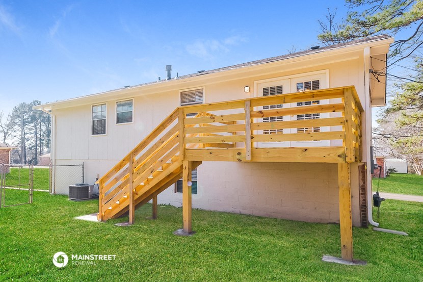 the front of a house with a wooden deck