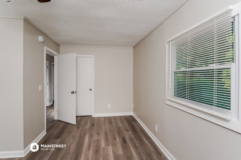 the spacious living room of an apartment with a large window