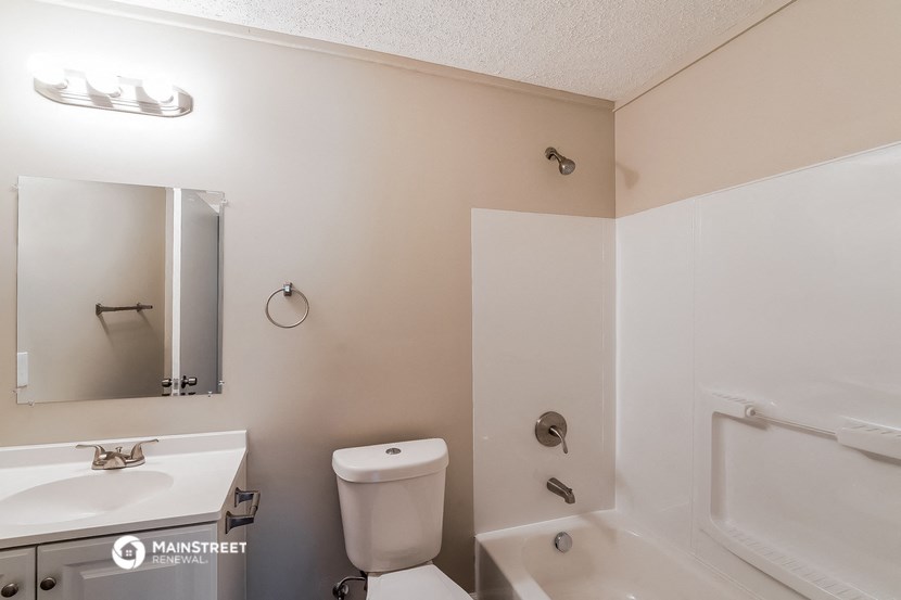 a bathroom with a toilet and a sink and a bath tub