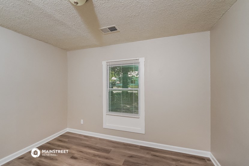 the spacious living room of an apartment with a window